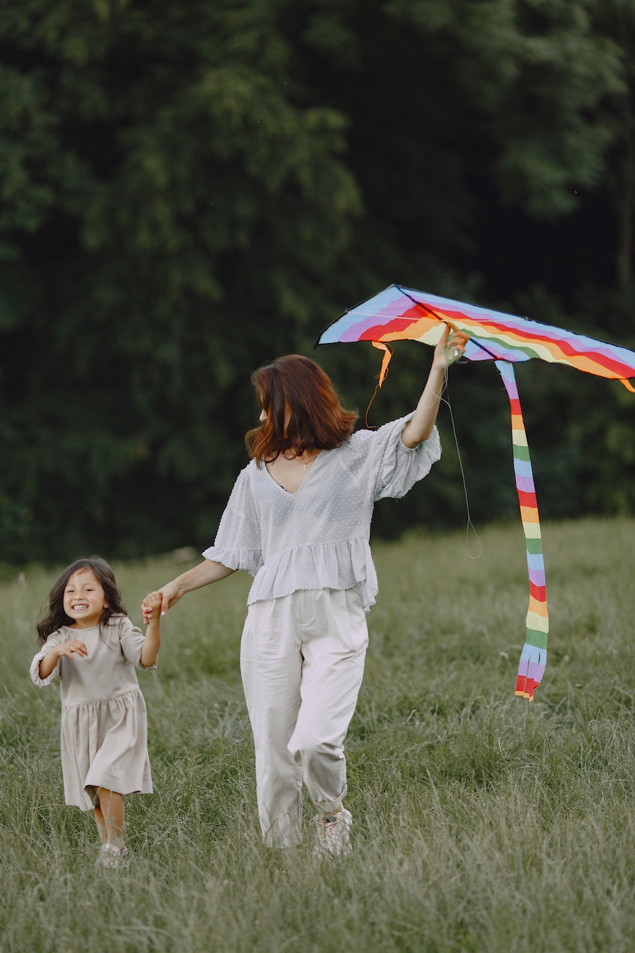 A photo of a Family Assistant helping with a little girl and her kite.