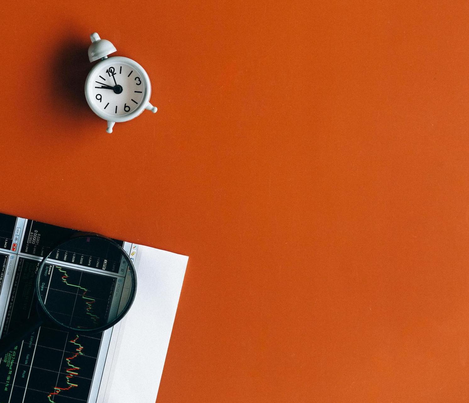 Financial performance graphs with clock showing time-sensitive family office investment management and advisory services.